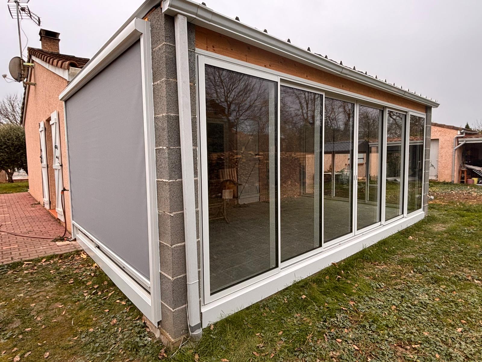 photo d'une terrasse fermée par des baies vitrées et installation d'un store