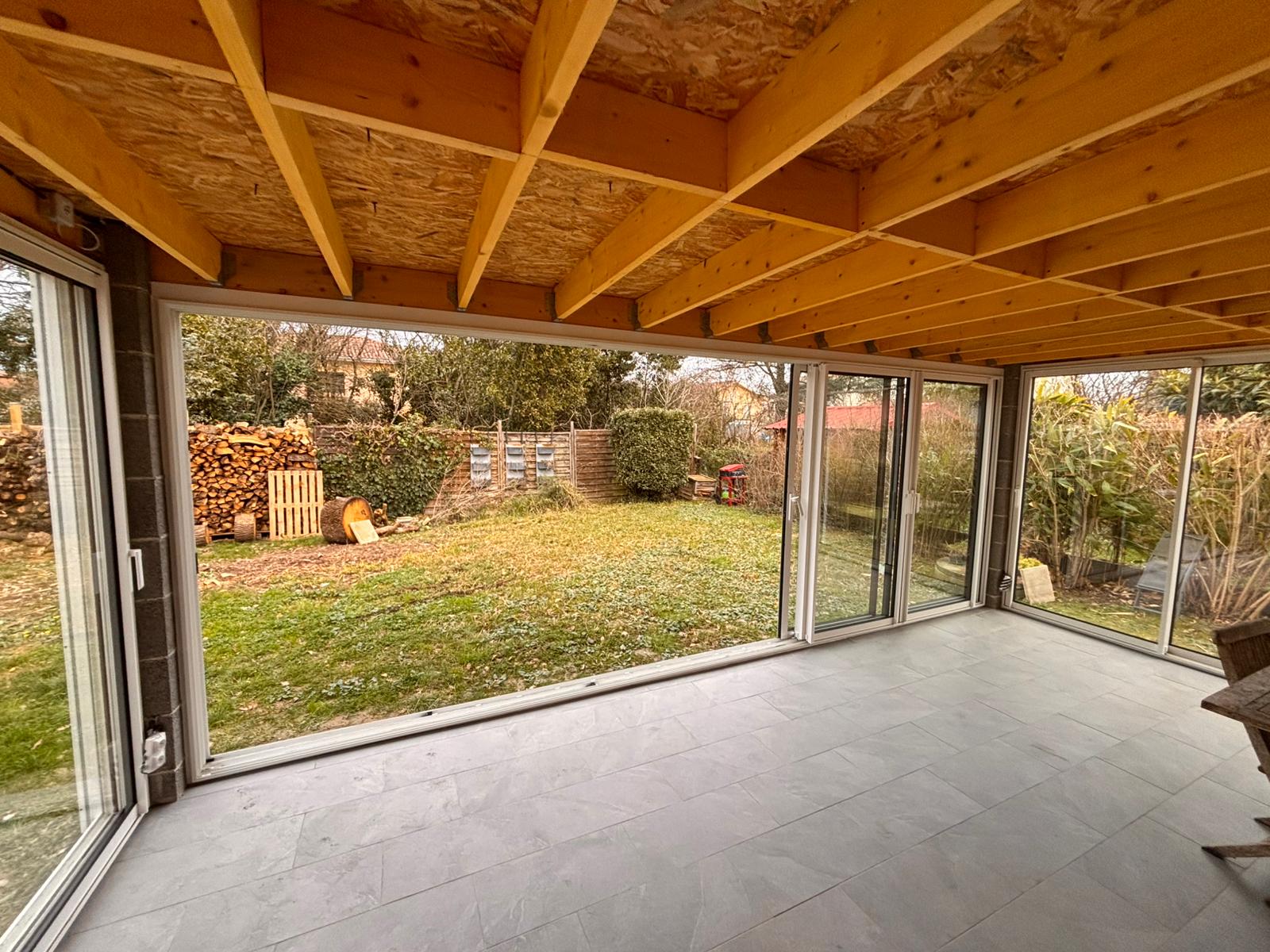 photo d'une terrasse fermée par des baies vitrées