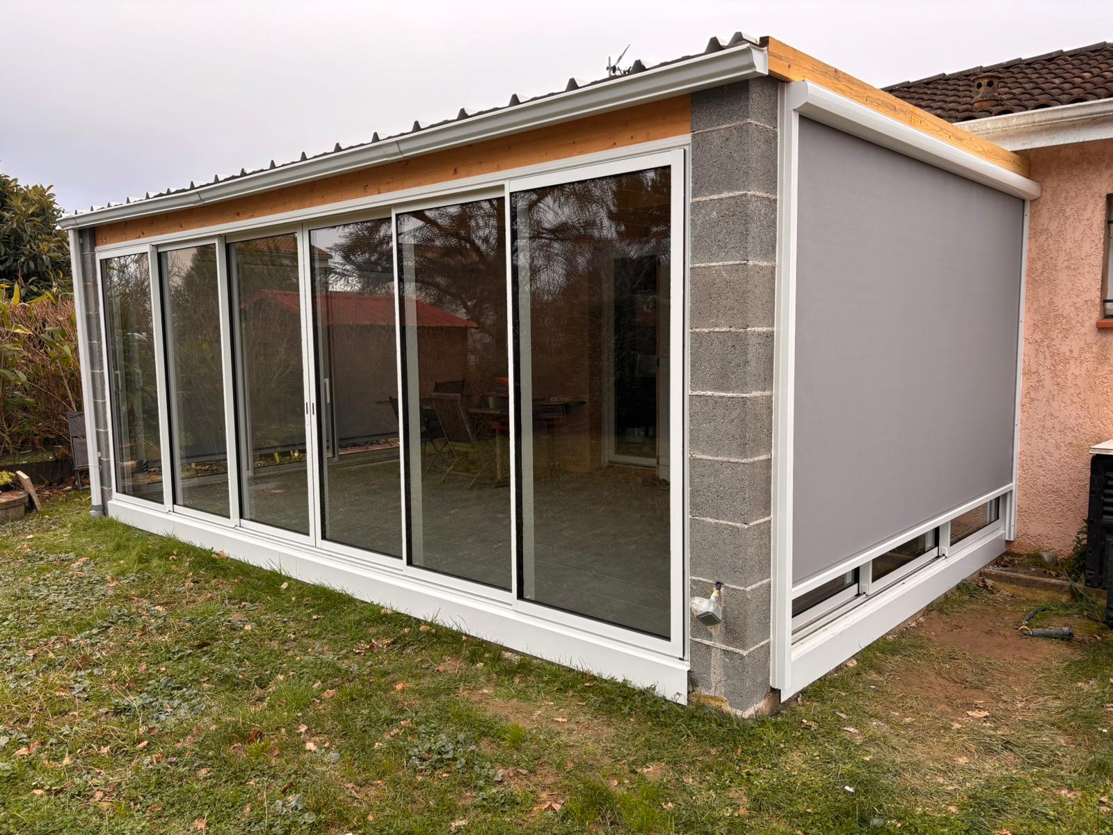 photo d'une terrasse fermée par des baies vitrées et installation d'un store