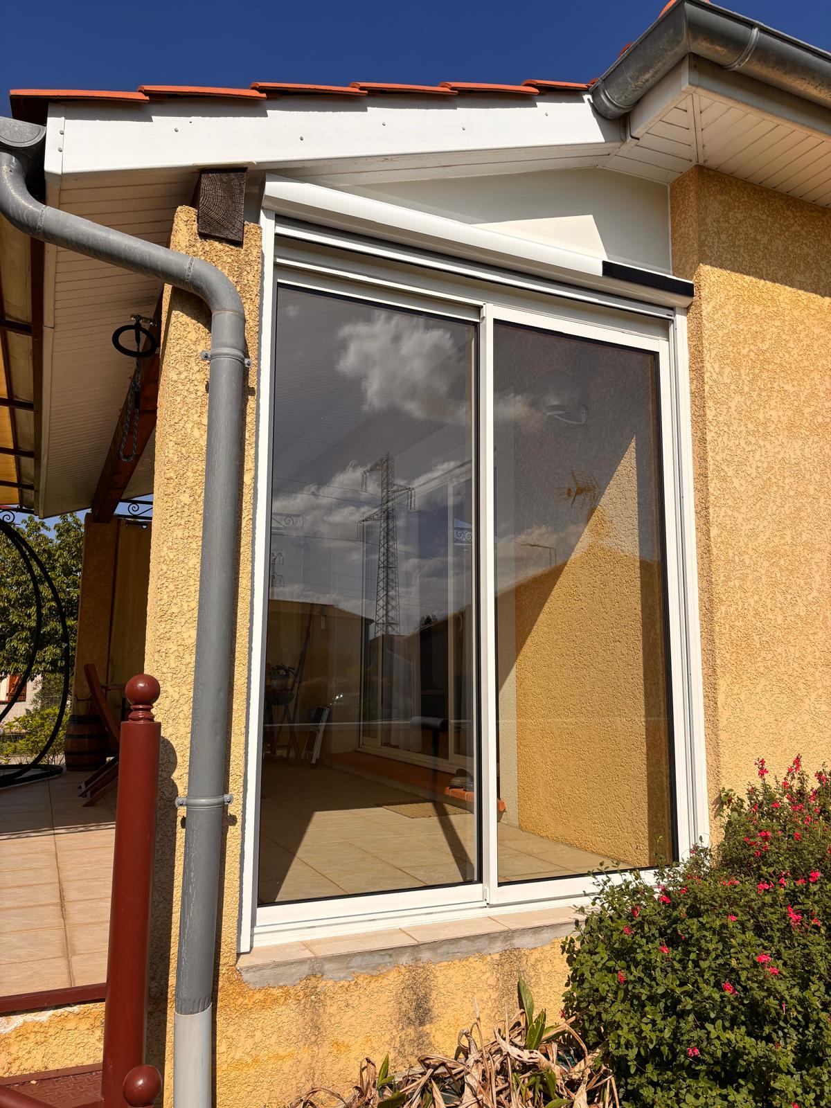 photo vu de l'extérieur du coulissant installé pour fermer une terrasse d'un côté