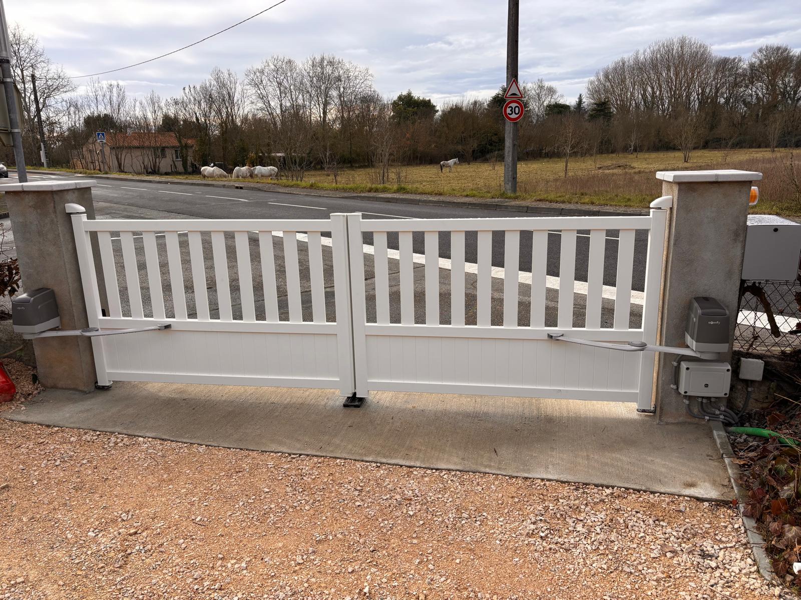 Photo d'un portail blanc en aluminium avec motorisation Somfy