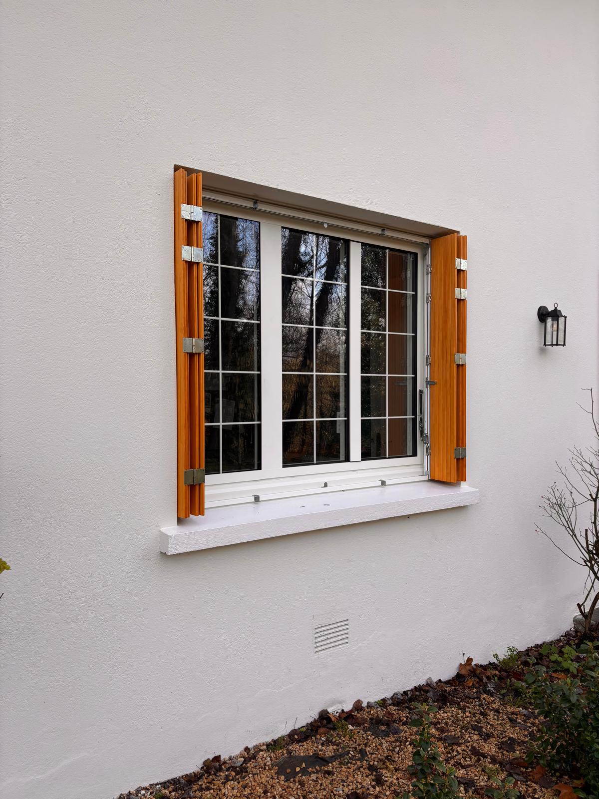 Persienne en bois sur fenêtre en aluminium