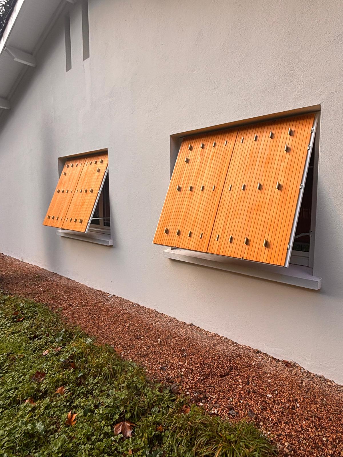 Persiennes en bois sur fenêtres en aluminium