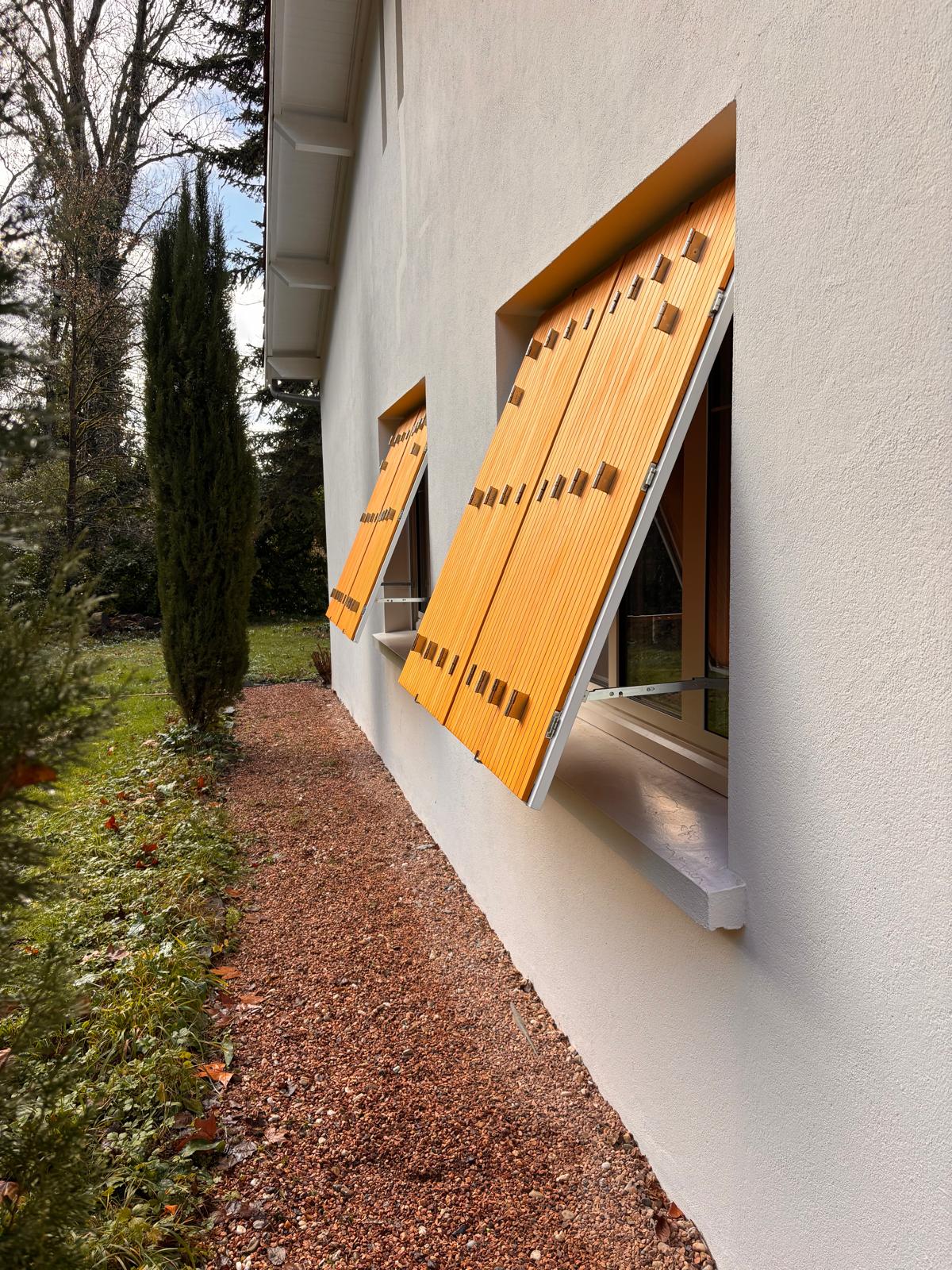 Persiennes en bois sur fenêtres en aluminium