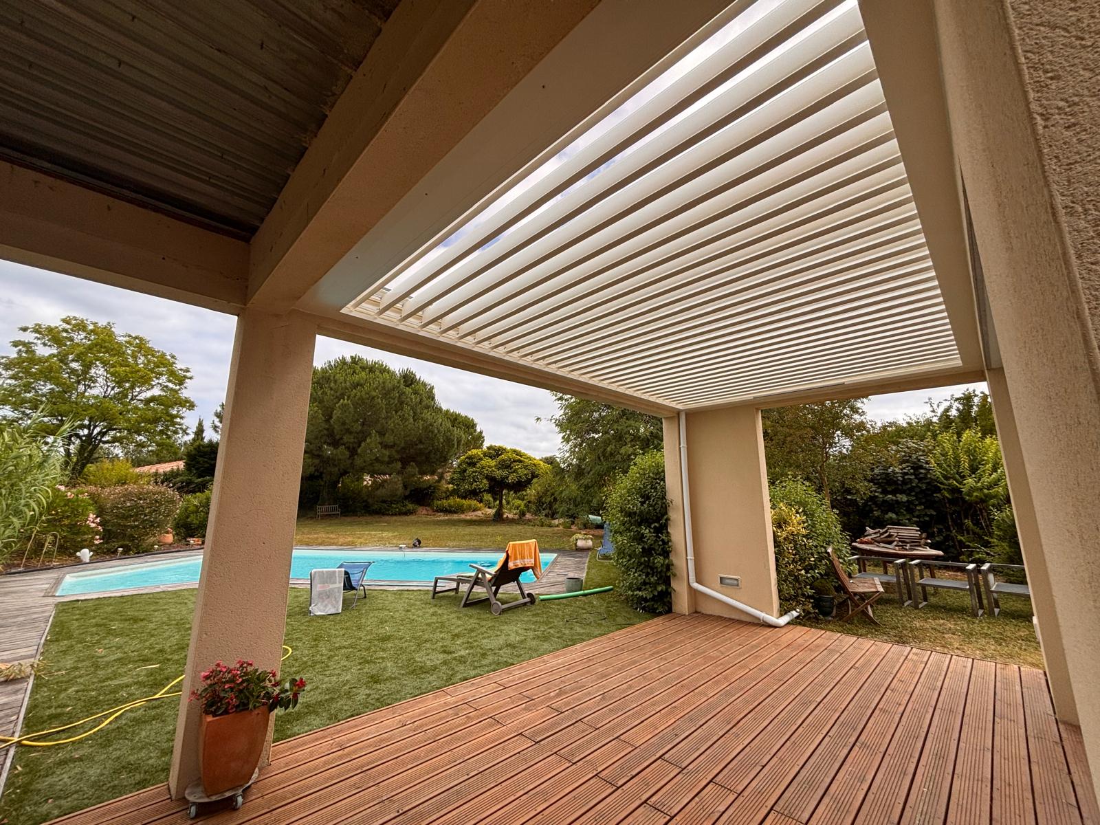 pergola bioclimatique avec lames ouvertes, installée entre des murs à Toulouse par Occ'Fermetures