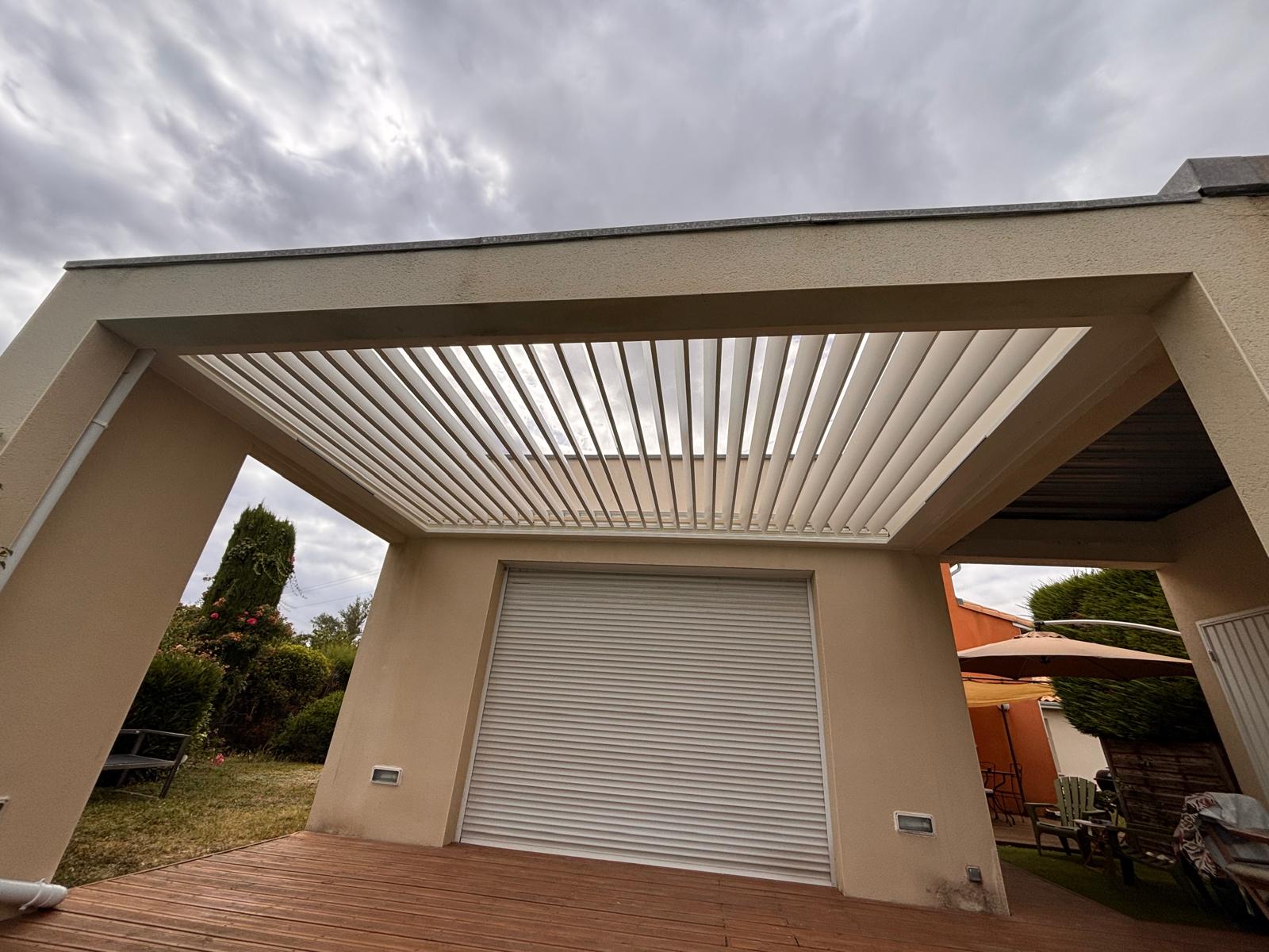 vue de face d'une pergola bioclimatique avec lames ouvertes, installée entre des murs à Toulouse par Occ'Fermetures