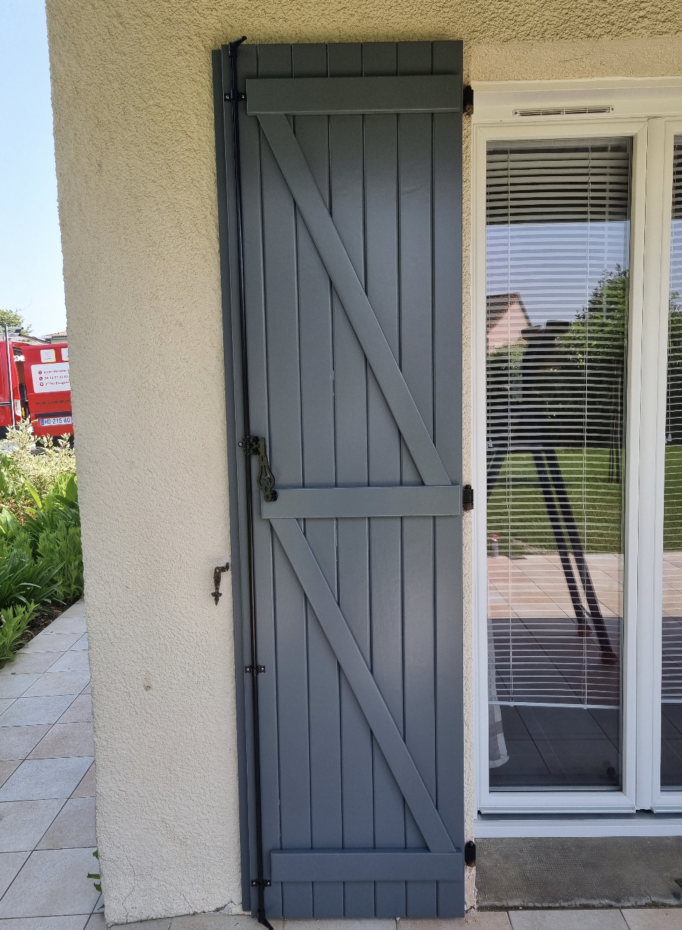 photo d'une porte-fenêtre avec un volet battant en bois gris
