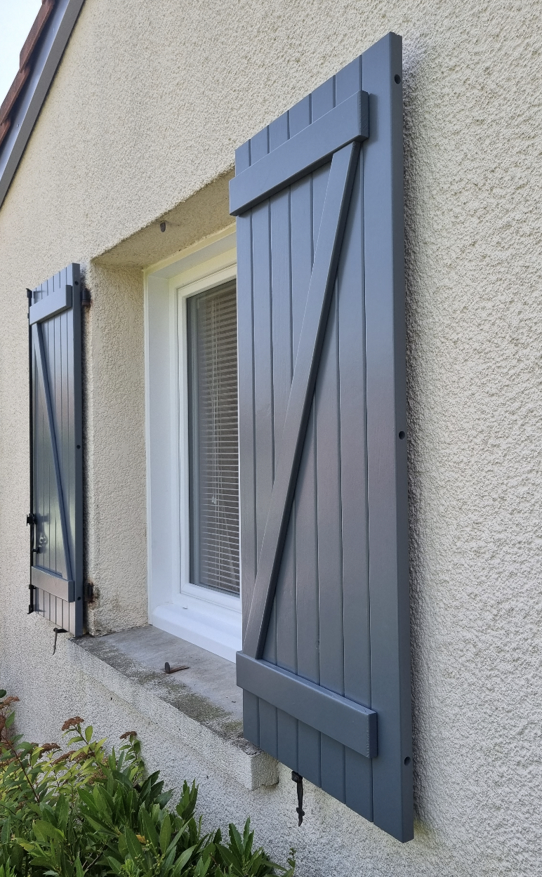 photo d'une fenêtre en PVC blanc avec les volets battants en bois gris