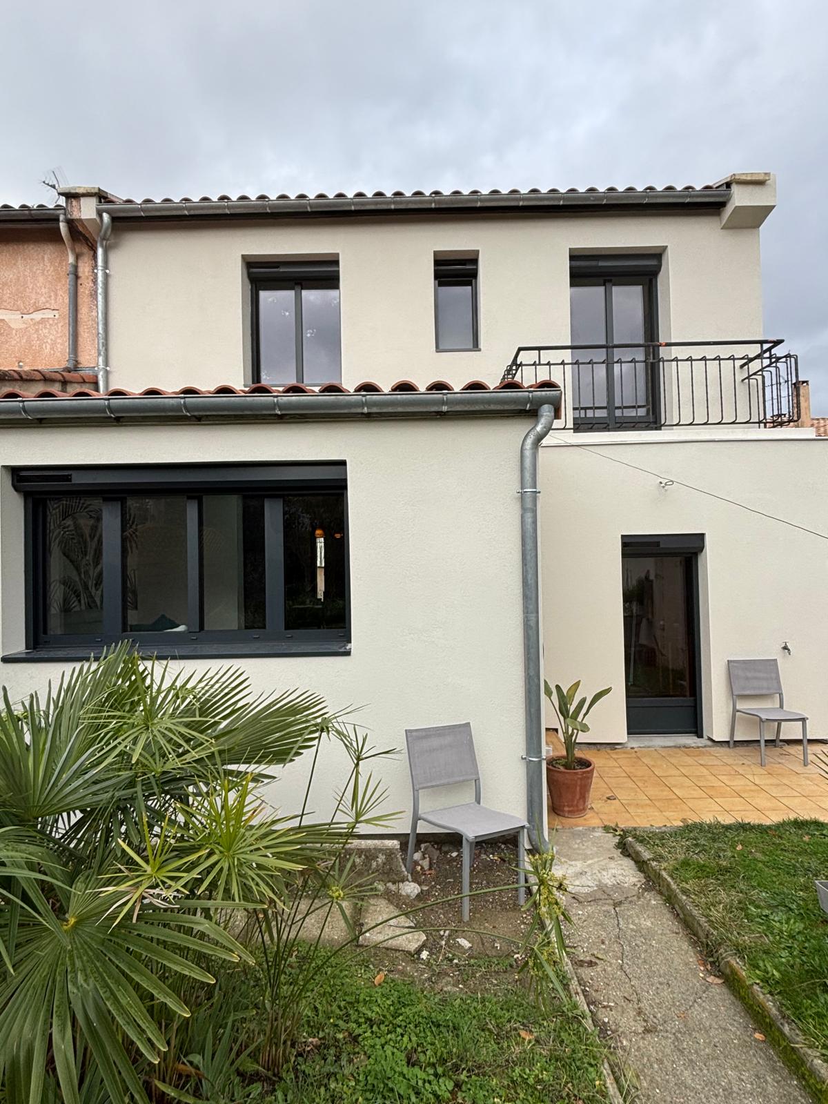 photo d'une maison avec des fenêtres en aluminium gris anthracite et porte