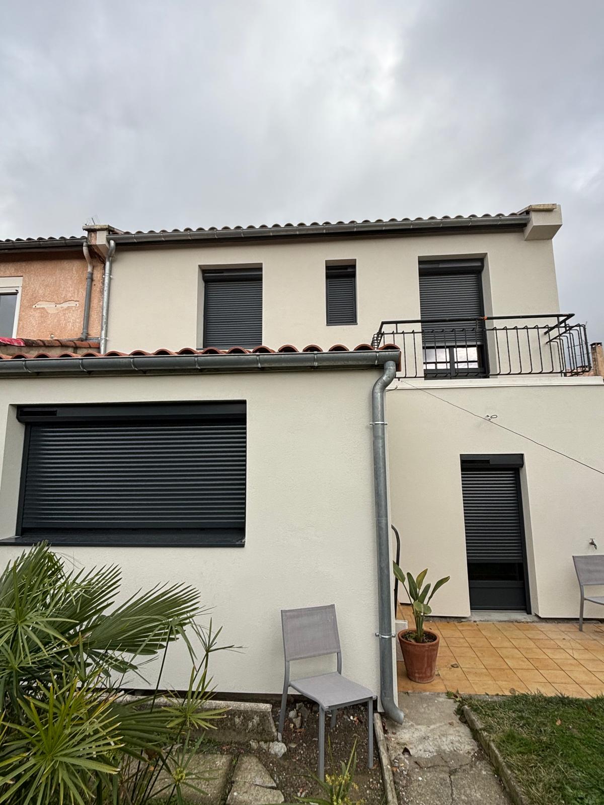 photo d'une maison avec des fenêtres en aluminium gris anthracite et volets roulants solaires